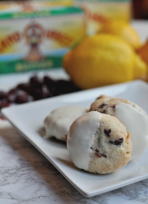 Easy recipe to make White Chocolate Cranberry Cookies. A buttery shortbread cookie with pops of lemon and cranberry and then dipped in white chocolate. https://diningwithalice.com/desserts/white-chocolate-cranberry-cookies/