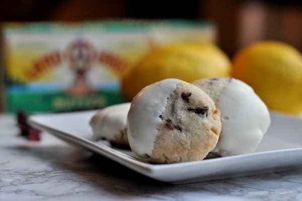 Easy recipe to make White Chocolate Cranberry Cookies. A buttery shortbread cookie with pops of lemon and cranberry and then dipped in white chocolate. https://diningwithalice.com/desserts/white-chocolate-cranberry-cookies/