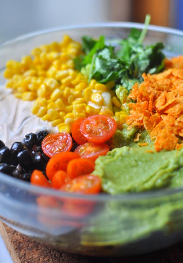 This easy Taco Salad is a quick recipe and is layered with Doritos, ground beef and your favorite taco toppings like corn, cilantro, Nacho Cheese doritos, guacamole, tomatoes, sour cream.