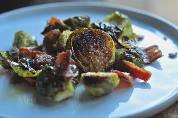 Crispy and roasted Brussels Sprouts recipe with bacon and drizzled with balsamic glaze. Simple recipe with only two ingredients great sidedish for holidays! Crispy brussels sprouts on a plate.